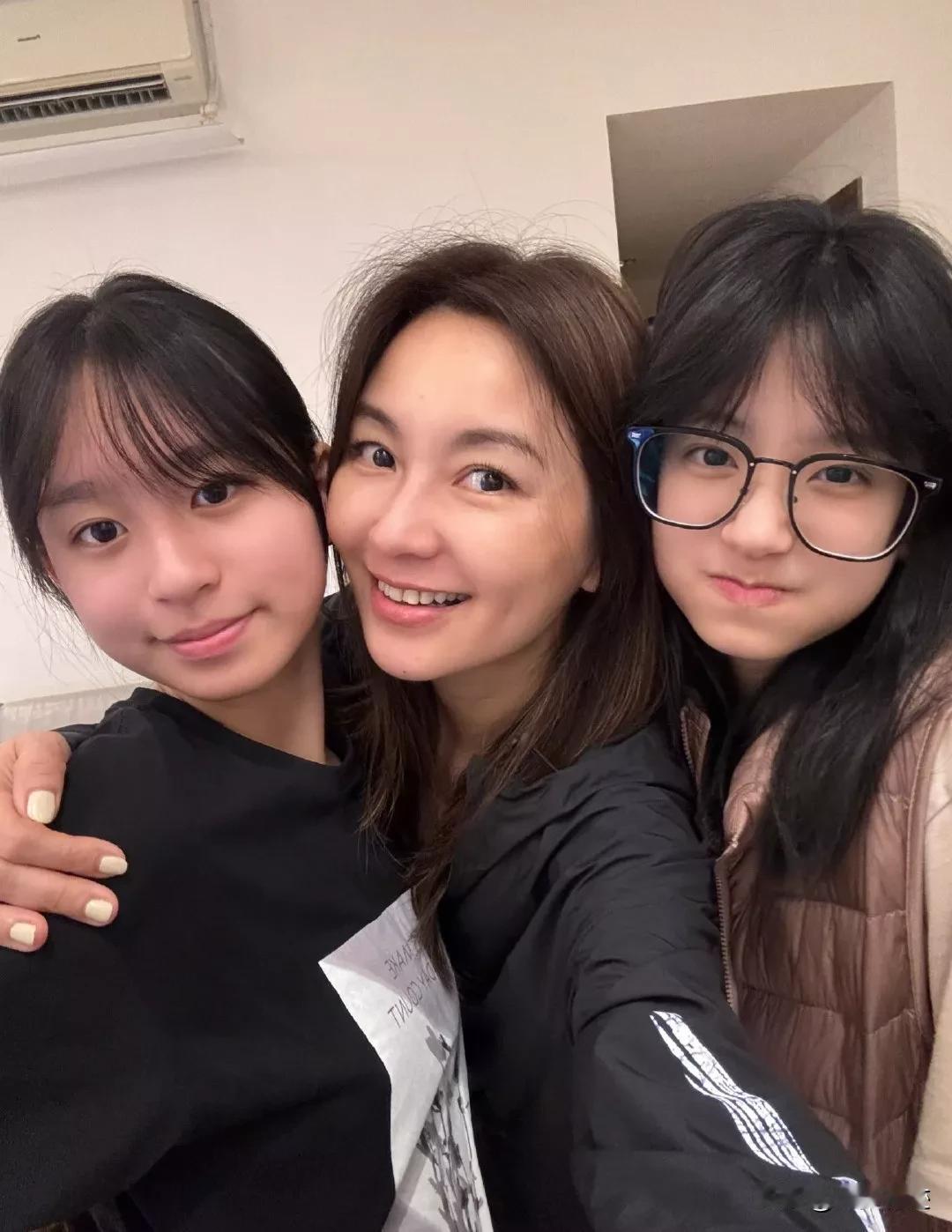 中间那位大美女是谁？有人还能认出她吗？
左右两边的小美女是她的女儿，全素颜的她，