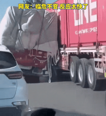 路上一大货车突然爆胎，车身就要侧翻，在千钧一发之际，邻车司机快速上前顶住，大货车