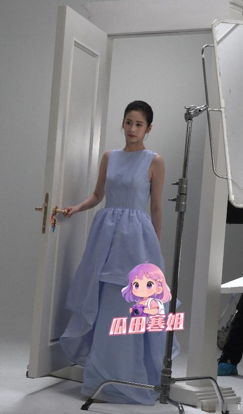 颖儿冷脸拍摄疑心情不佳 颖儿梳着利索的低花苞头，身穿蓝色连衣长裙，看起来还挺有少