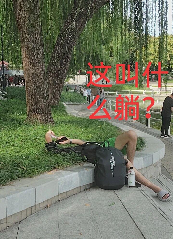 小伙子是有多累呀？大白天就四仰八叉地躺在草坪上，旁边那么多人。换我，我可不敢。