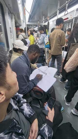 广州地铁上有网友拍到一位正在认真学习的黑人留学生。
当时他正坐在地铁椅子上做填空