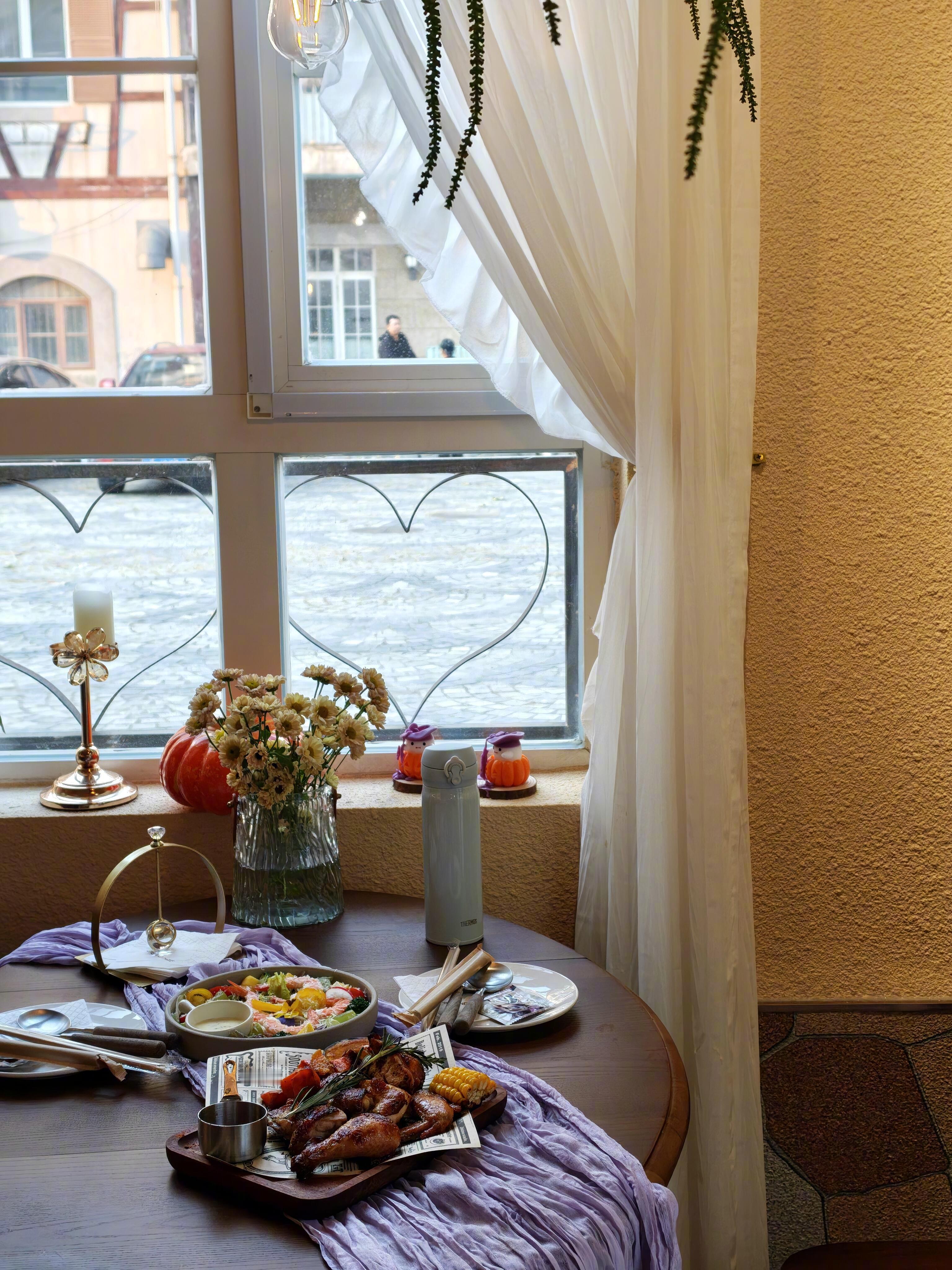 循着暖光推门，撞进满是生活气的温馨小馆。复古镜映着桌椅，南瓜摆件、黄小花与蕾丝桌