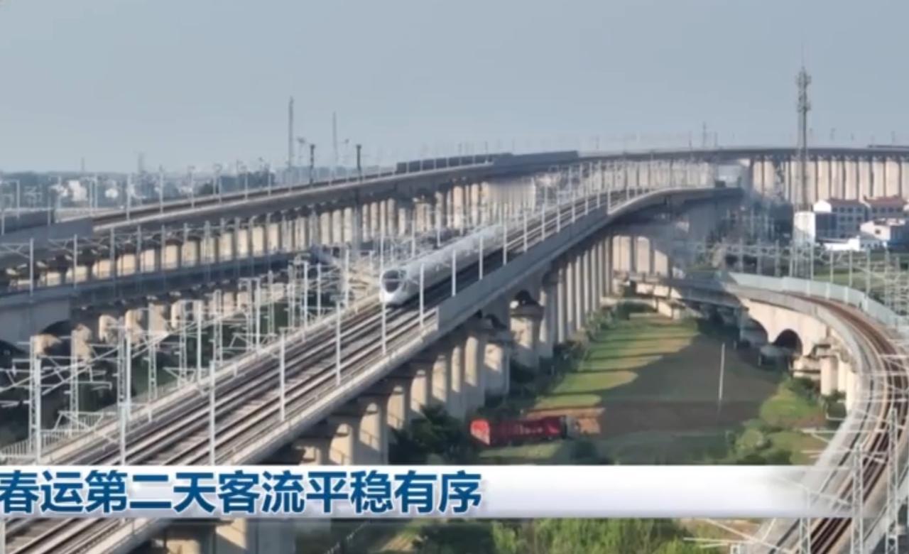 春运第二天，中国铁路迎来平稳有序的出行高峰。高铁如银龙穿梭在高架桥梁间，车站内红