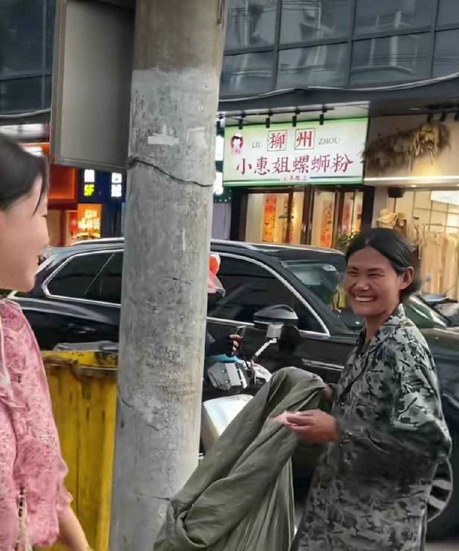 一名拾荒女子正在翻垃圾桶里的垃圾，旁边火锅店的老板娘，突然走了过去，一个举动，让