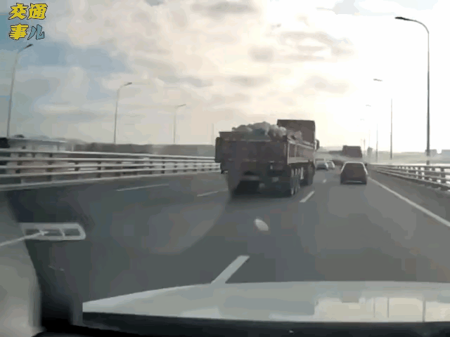 高速上一定要远离大货车，图中小车在慢车道上开得慢慢悠悠的，和大货车长时间并行，很