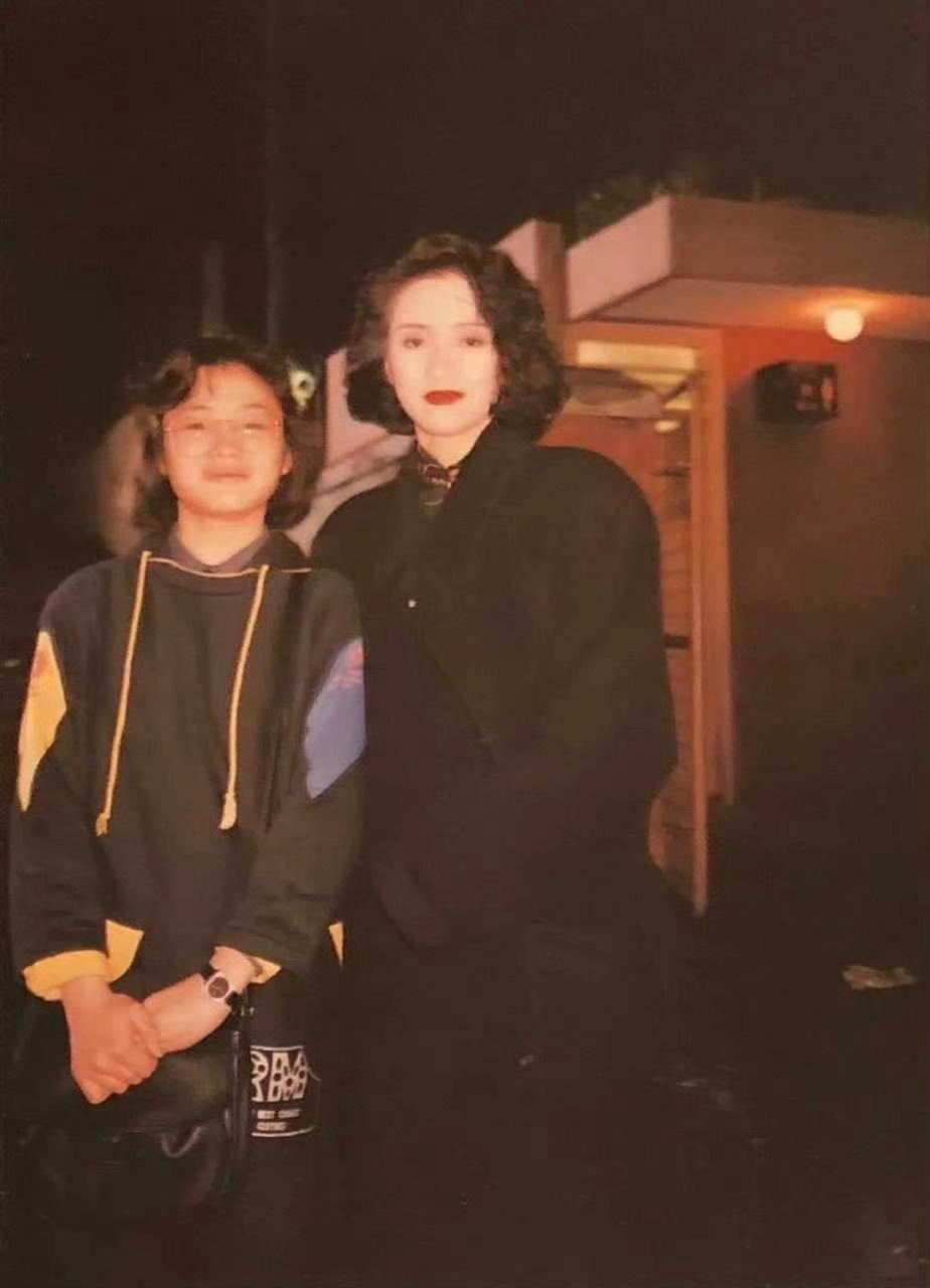 1987年，《胭脂扣》拍摄期间。画面右侧23岁的梅艳芳，刚结束当日拍摄，欣然停下