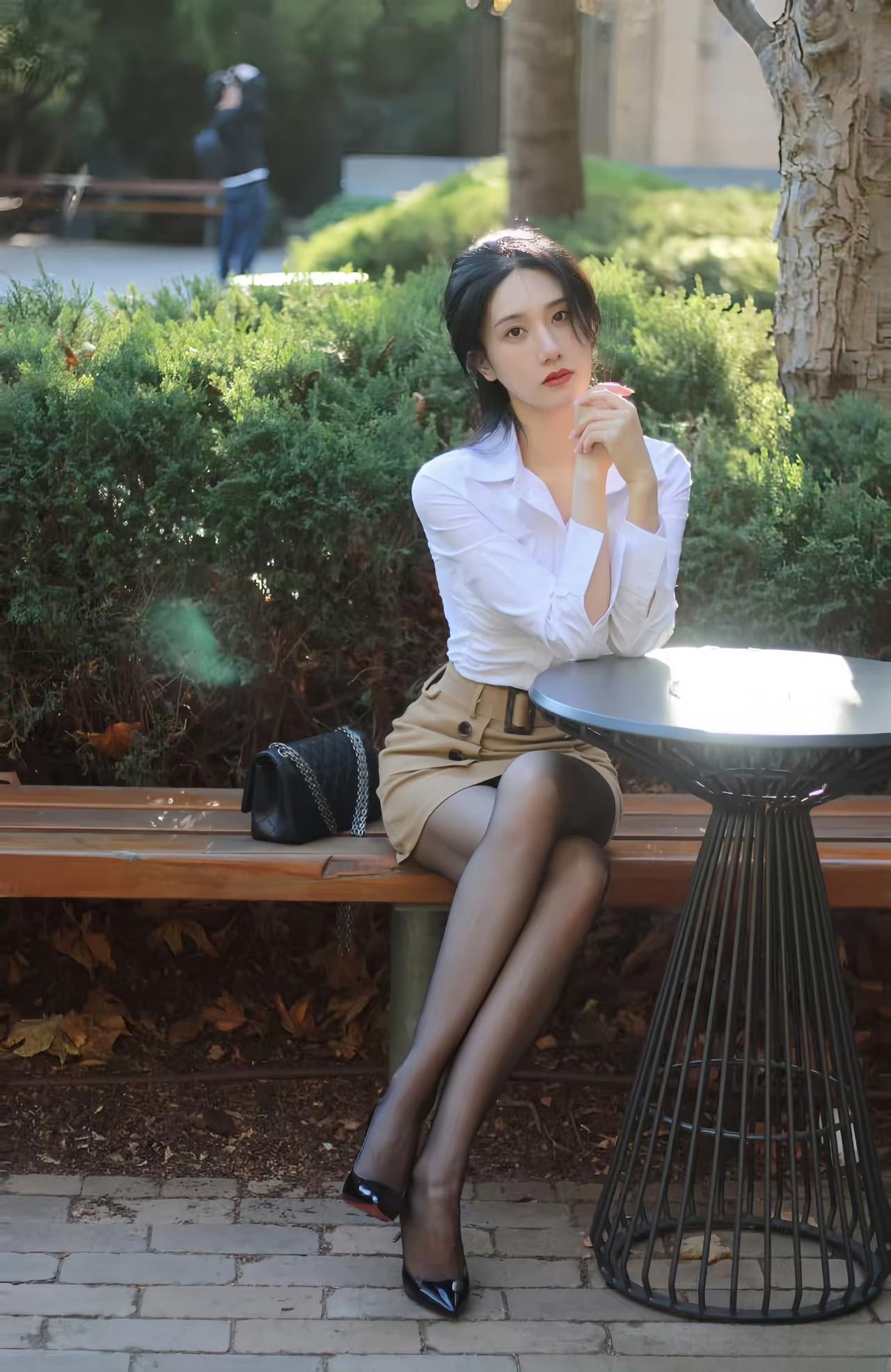 白色衬衫简约干练，经典的版型为整体注入了职场的专业气质；卡其色高腰短裙设计精致，