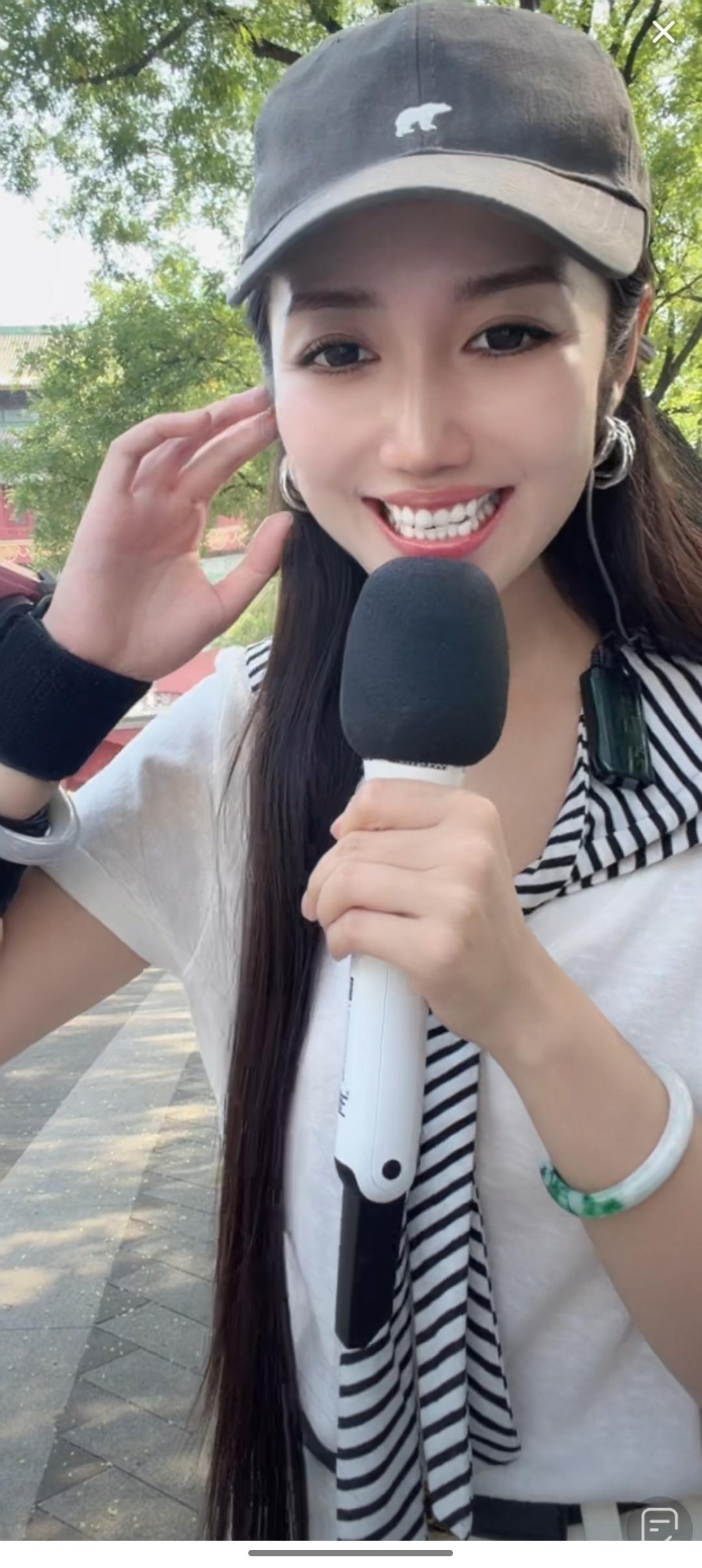 一个女孩在户外拿着麦克风微笑。