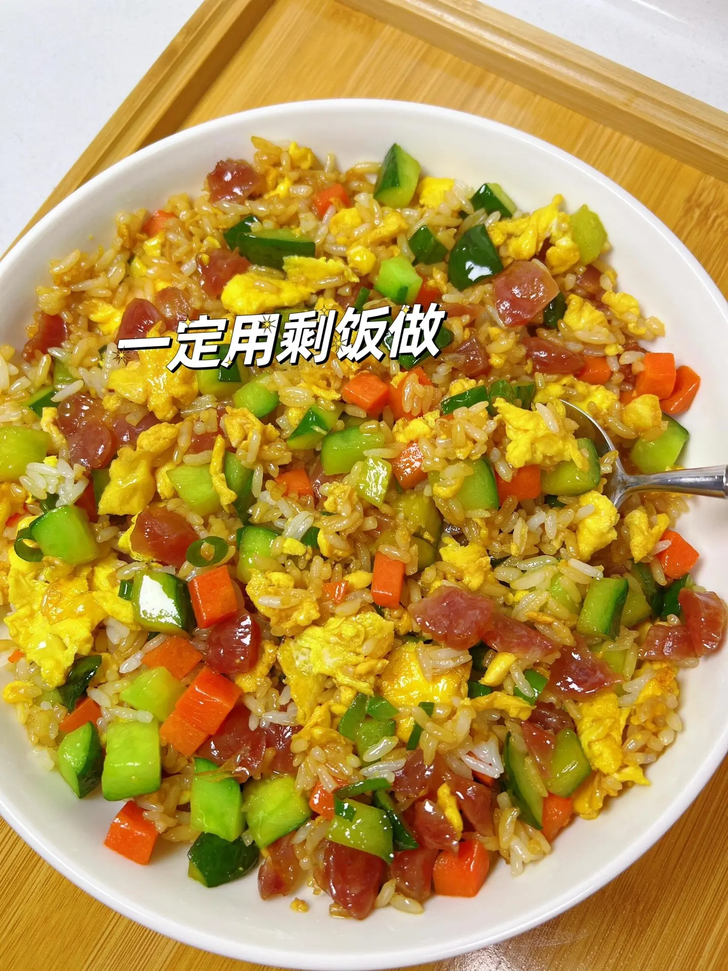 在家的炒饭这样做真的香懵了。一出锅满屋飘香，做法巨简单，快试试吧！
食材：米饭，腊肠丁，黄瓜丁，鸡蛋，胡萝卜丁，葱花
做法：
1⃣️油热炒黄瓜丁，腊肠，胡萝卜丁，加一点盐炒至断
生，盛出备用
2⃣️油热炒散鸡蛋，倒入剩米饭，蔬菜和腊肠，加1勺
生抽，1勺蚝油炒匀，加葱花出锅
