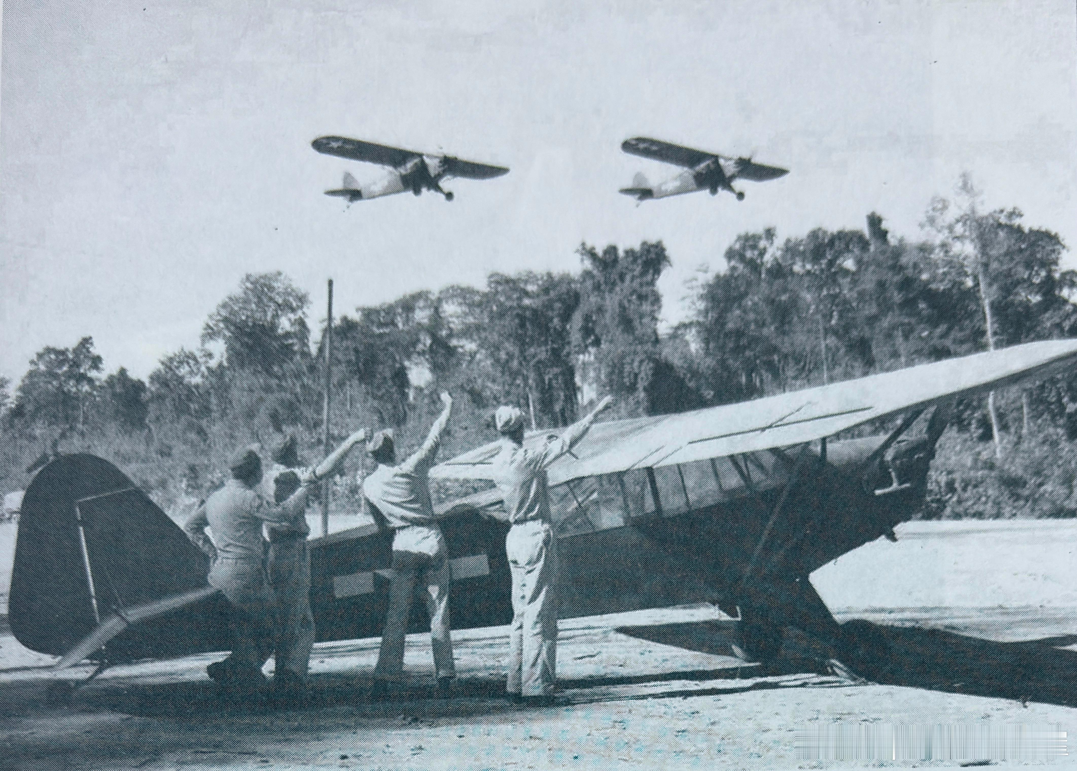 在缅北一个机场上，美军地勤人员向飞跃树梢的2架美军观察机招手军事历史全触达