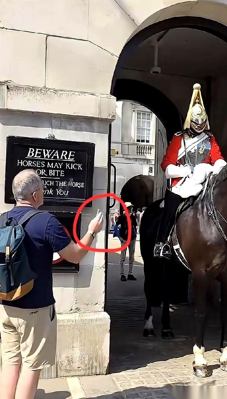 一张百元大钞，被一只布满皱纹的手捏着，顺着英国皇家骑马卫兵锃亮的高筒皮靴，直直塞