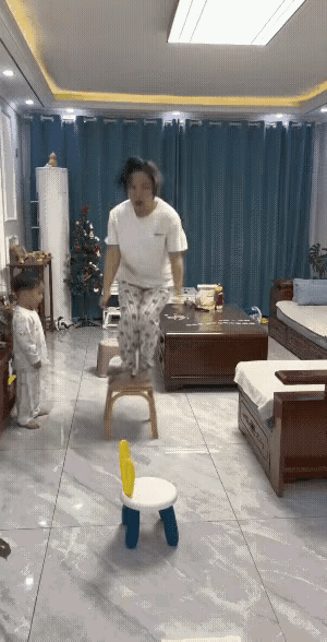 妈妈陪孩子在客厅里面玩跳一跳的游戏，但是这个代价也太大了吧？客厅里面隔着一定距离
