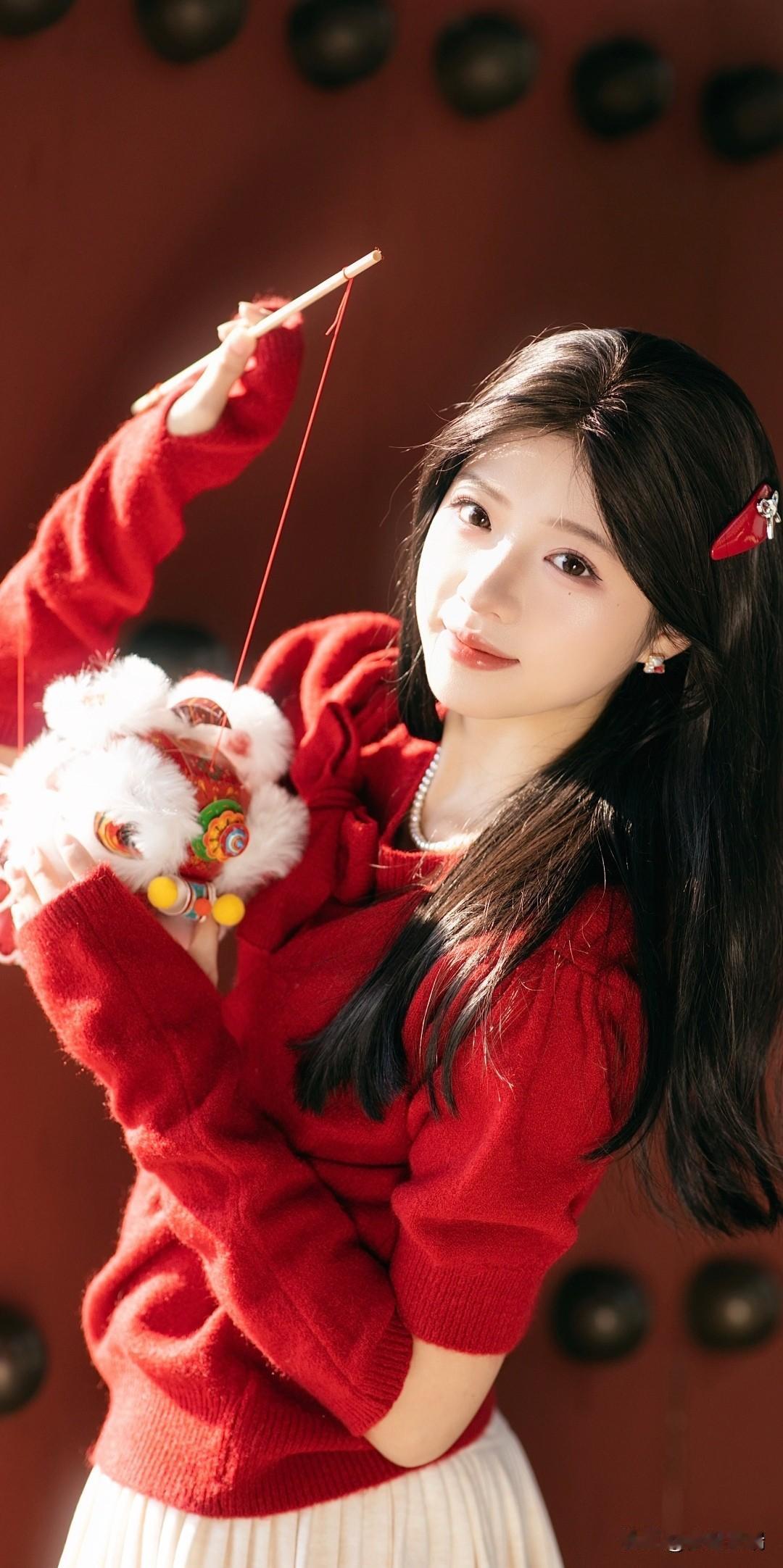 冬日暖阳下，红衣少女手捧吉祥玩具，微笑如初，㊗️大家新年快乐！