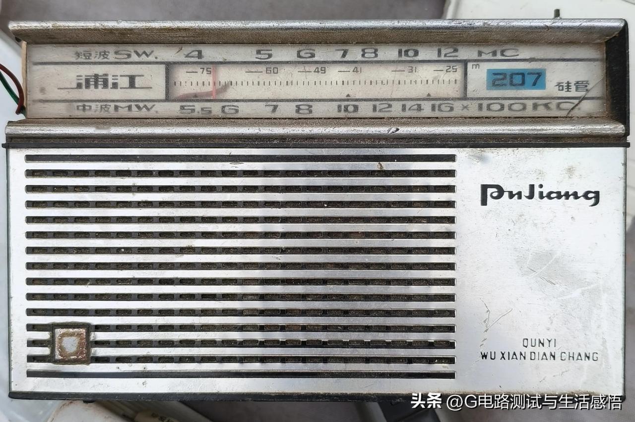 老旧的浦江207硅管收音机，布满岁月的痕迹。刻度盘上的中波与短波、旧刻度清晰依旧