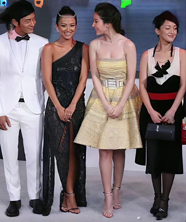 章子怡、刘亦菲、周迅、黄小明在台上时的一幕，一旁的黄小明高兴坏了控制不住的把头扭