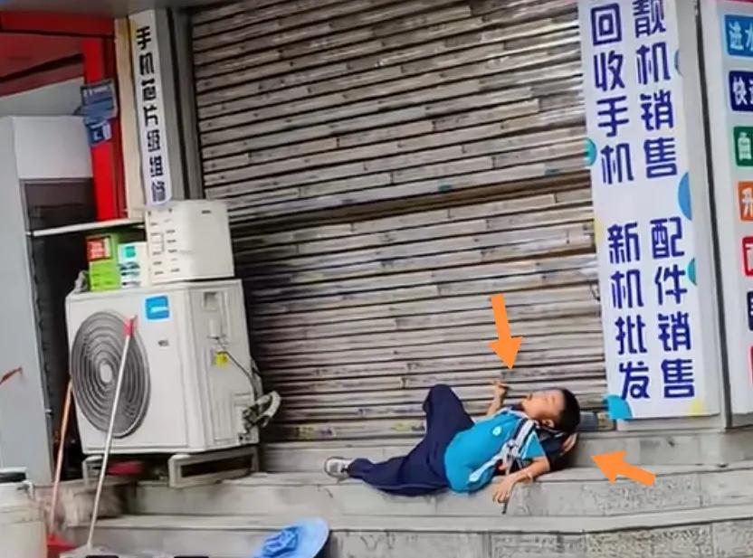 一学生躺睡台阶头枕包右手搂串。