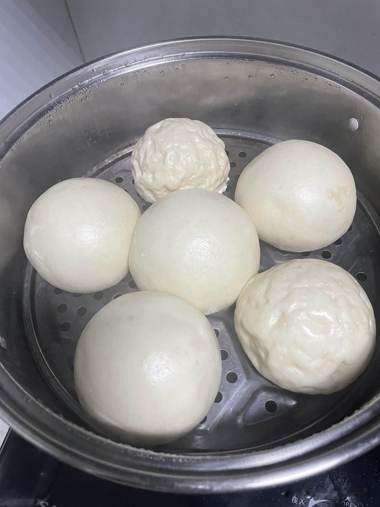 这两个馒头是怎么了？我们老家说是鬼捏了，我问了豆包，豆包说没醒发好。

同一盆面