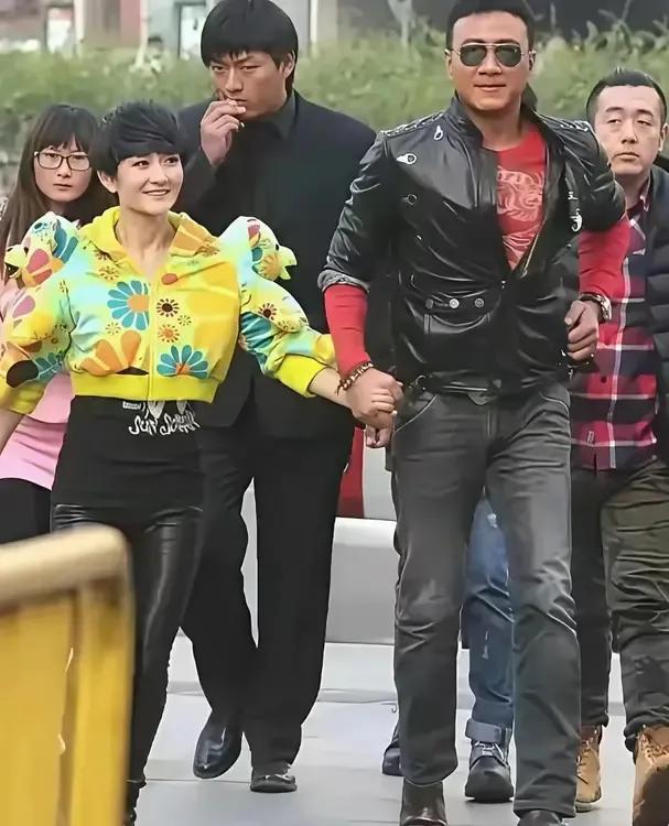 胡军酷帅和小迷妹谢娜手牵手，说说笑笑走在街上，胡军还不时看看镜头，这画面太有爱了