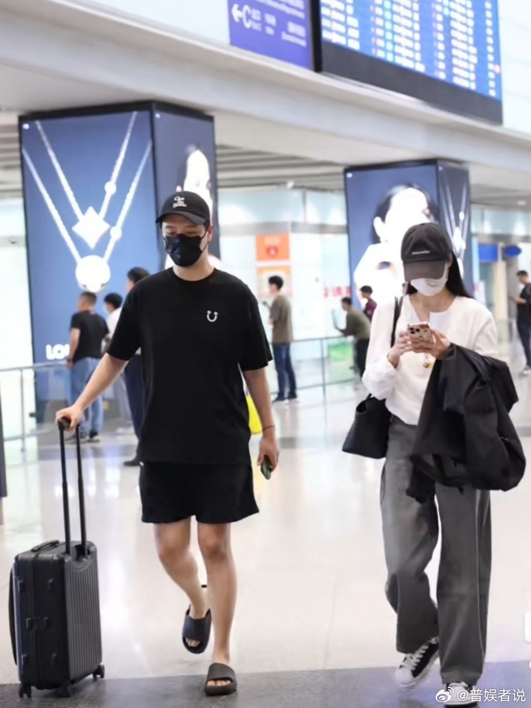 李纯回京，官宣男友马頔赶来接机。马頔全程帮姐姐推行李箱，李纯全程摆弄手机，两人戴