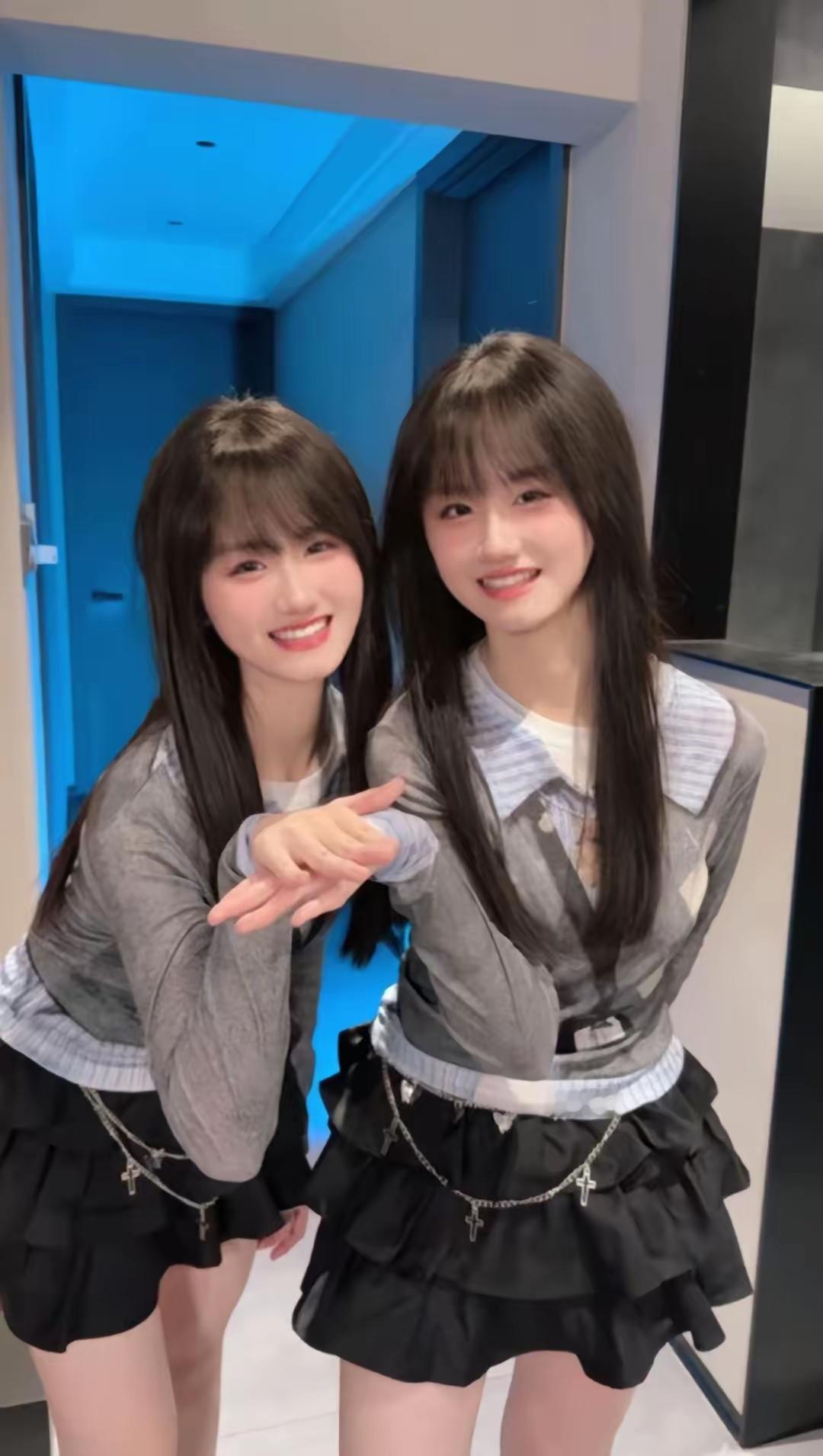 两个姐妹穿着相似，笑得很开心。