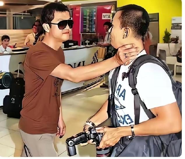 李亚鹏愤怒的象头雄狮，一只手抵住欲正面拍李嫣的那位娱记，嘴巴里还在情绪激动地吼着