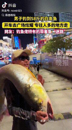 笑发财了！江西南昌，有个男子扛着58斤的大鱼在广场闲逛，引得众人围观。他特地开车