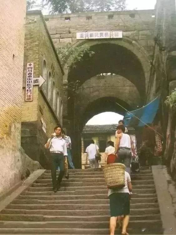 从照片上路人的穿着来看，这张照片拍摄时间应该是八十年代，城门的左侧有个指路牌，上