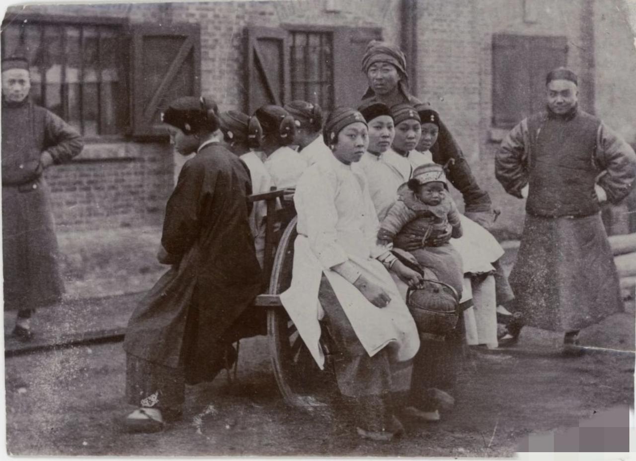 这是一张晚清时期，上海的老照片，一个车夫用独轮车推起八个女子和一个小孩子。
但是