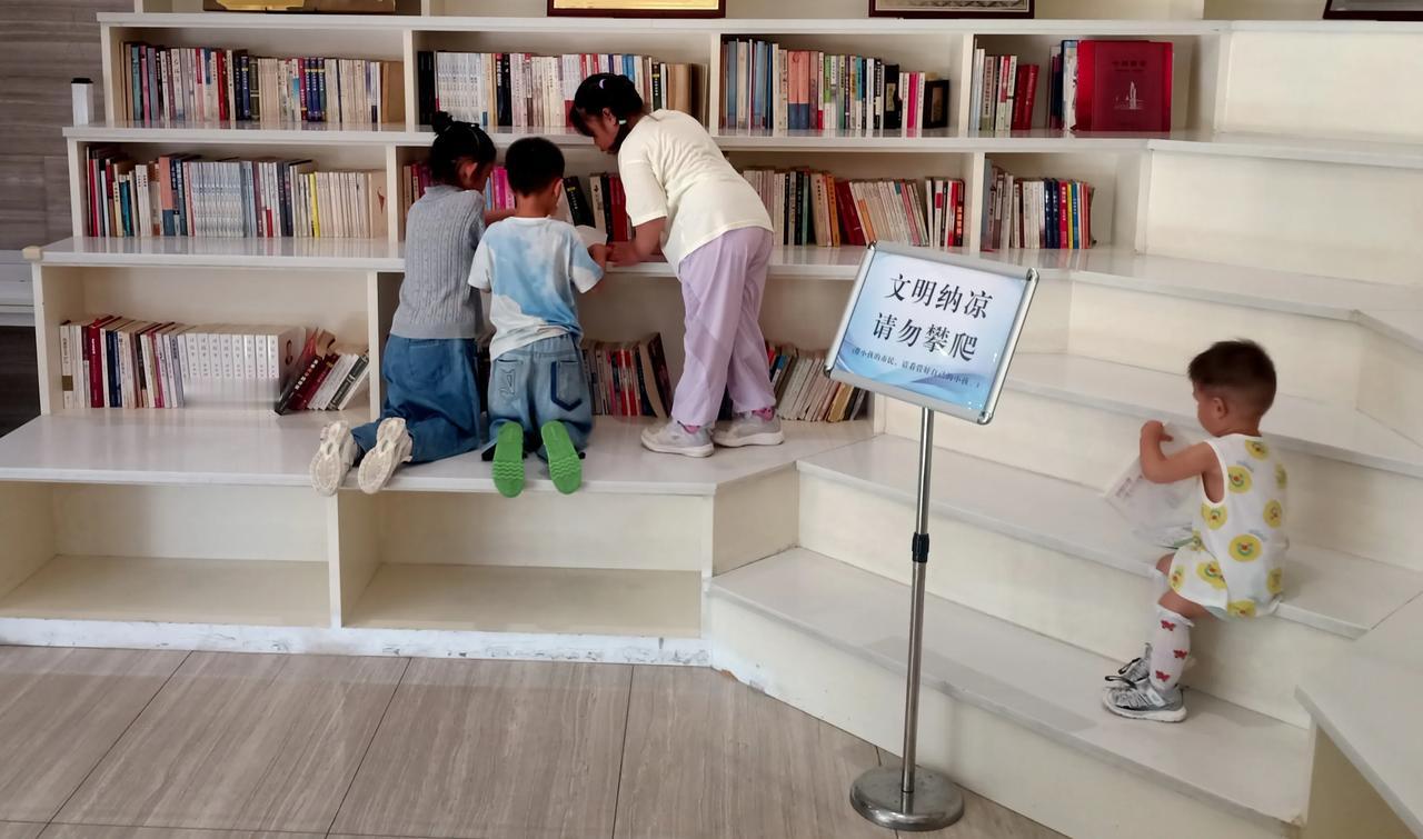 在某区政务中心“读书角”纳凉玩耍的孩童们。
