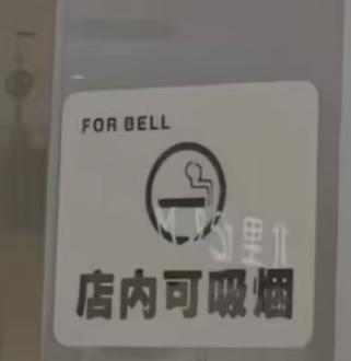 贵州贵阳一家商场内的咖啡店，在门店玻璃门上直接张贴 “店内可吸烟” 的标识，路人