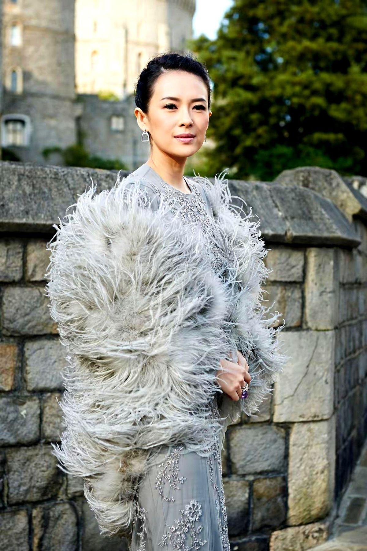 这组灰调照片，真有点把人看愣了。
灰色古堡石墙、同色礼服、再加一层羽毛披肩，颜色