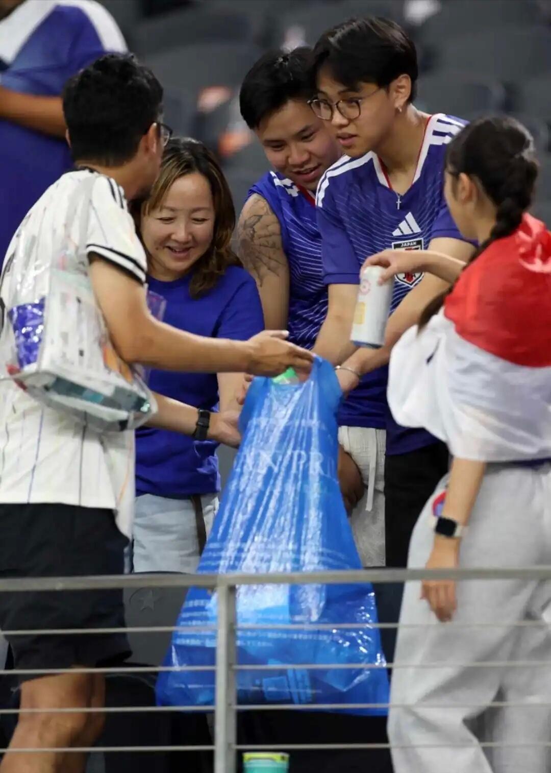 世界杯日本球迷披国旗坐轮椅捡垃圾疑摆拍体育场内轮椅球迷拾垃圾画面广为传播，细心网