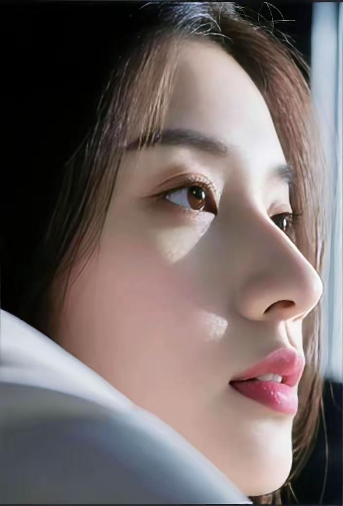 窗边沉思的少女，柔和的光影勾勒出温柔的轮廓。