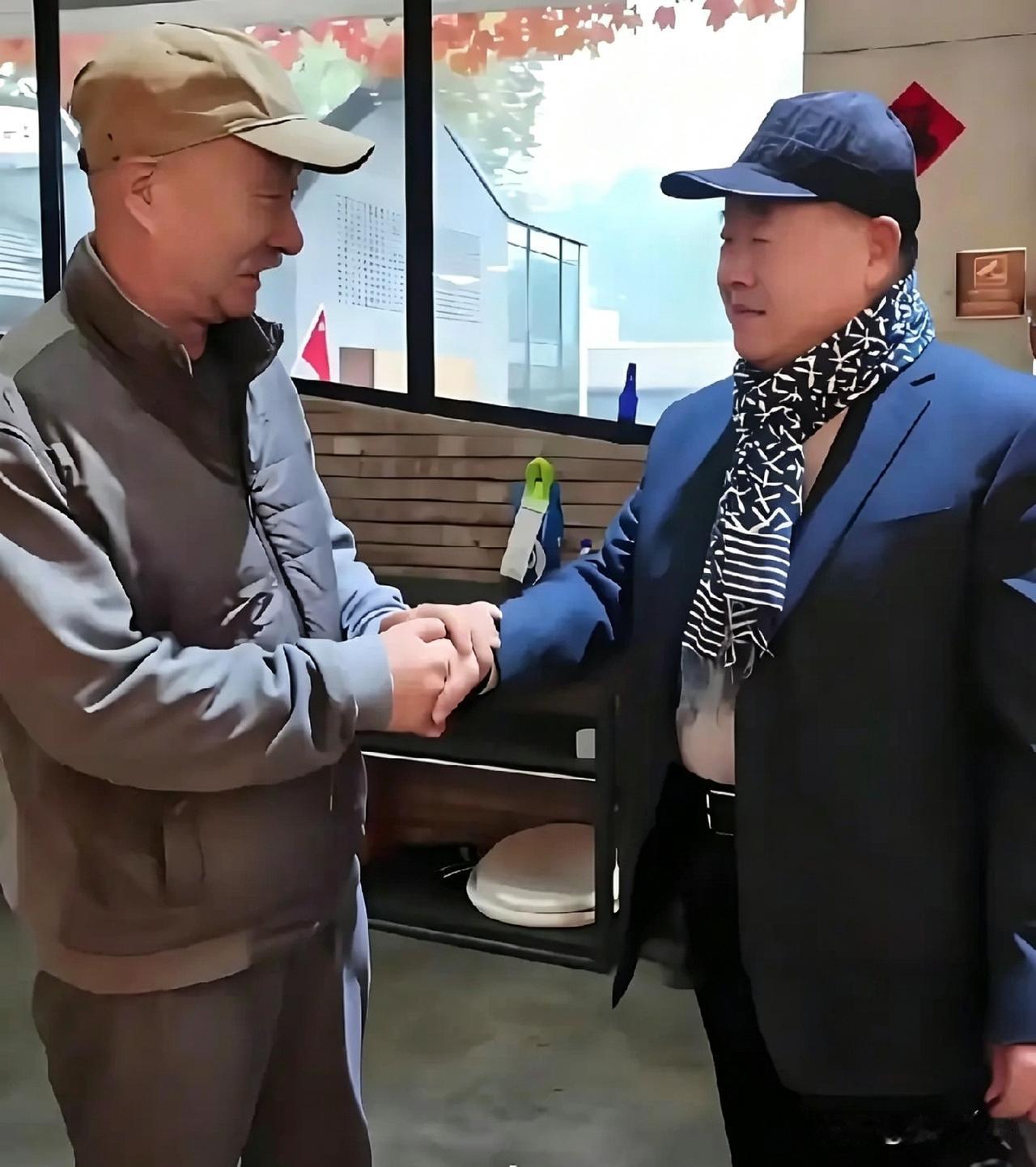 两位老友双手紧握，笑容温暖。