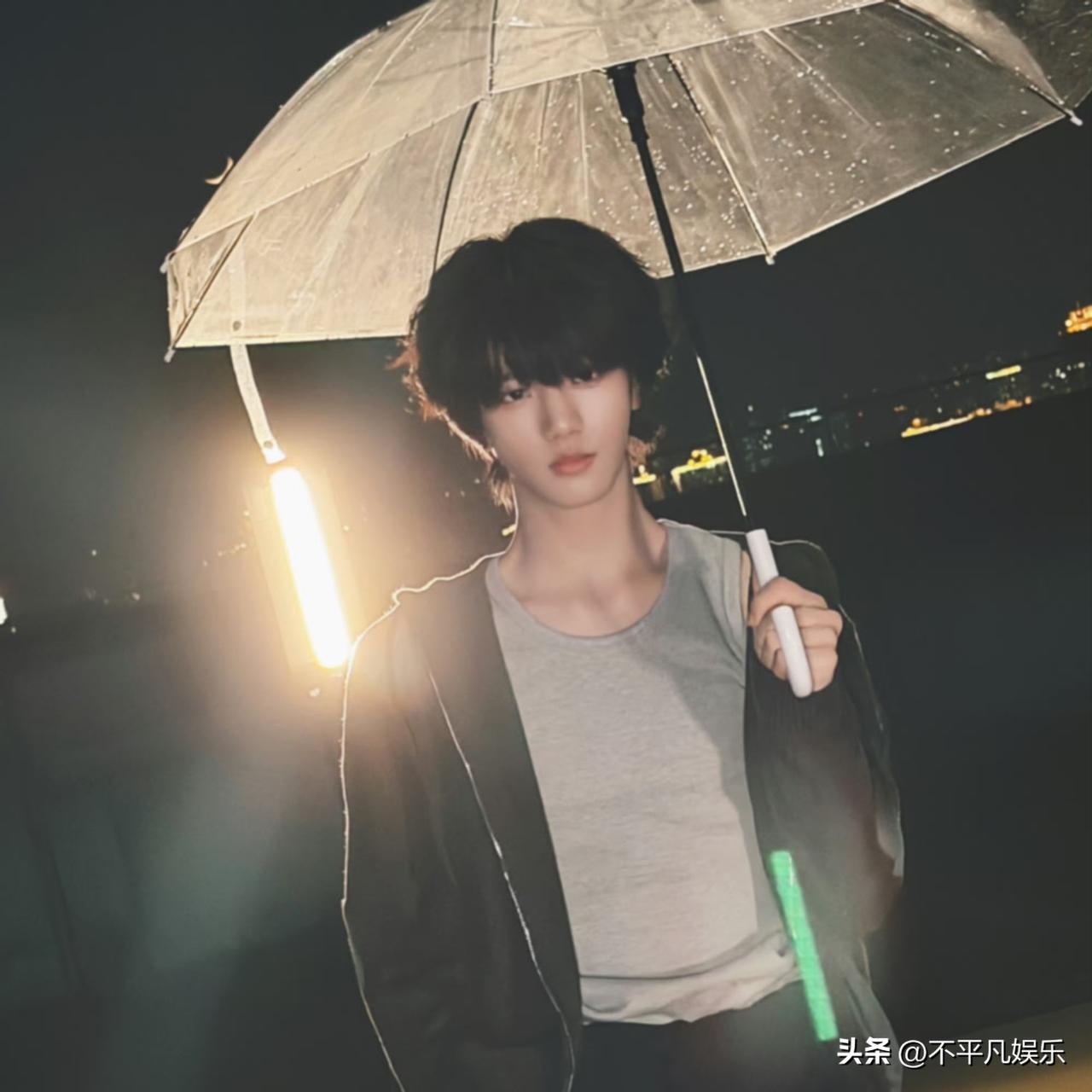 张函瑞的撑伞路透一出，粉丝的存图相册直接爆了。他穿浅色连帽卫衣站在海边檐下，手里