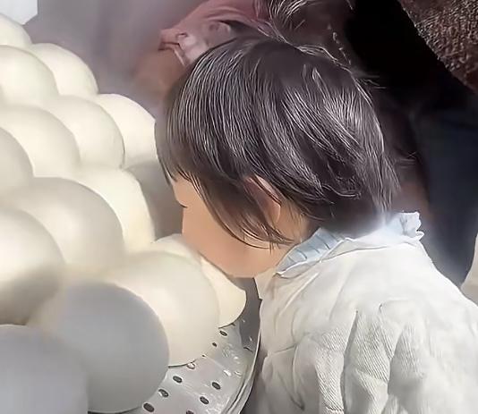 甘肃天水的一位一岁半萌娃，第一次跟着爸妈回乡过年。当外婆揭开蒸笼，大白馒头带着热