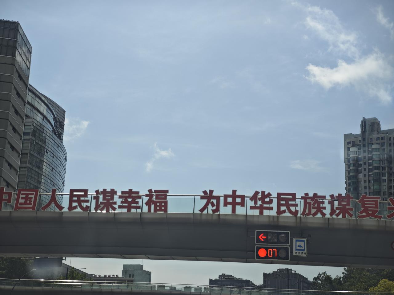 开车途经城区高架天桥，一眼望见天桥上醒目的红色大字：为中国人民谋幸福，为中华民族