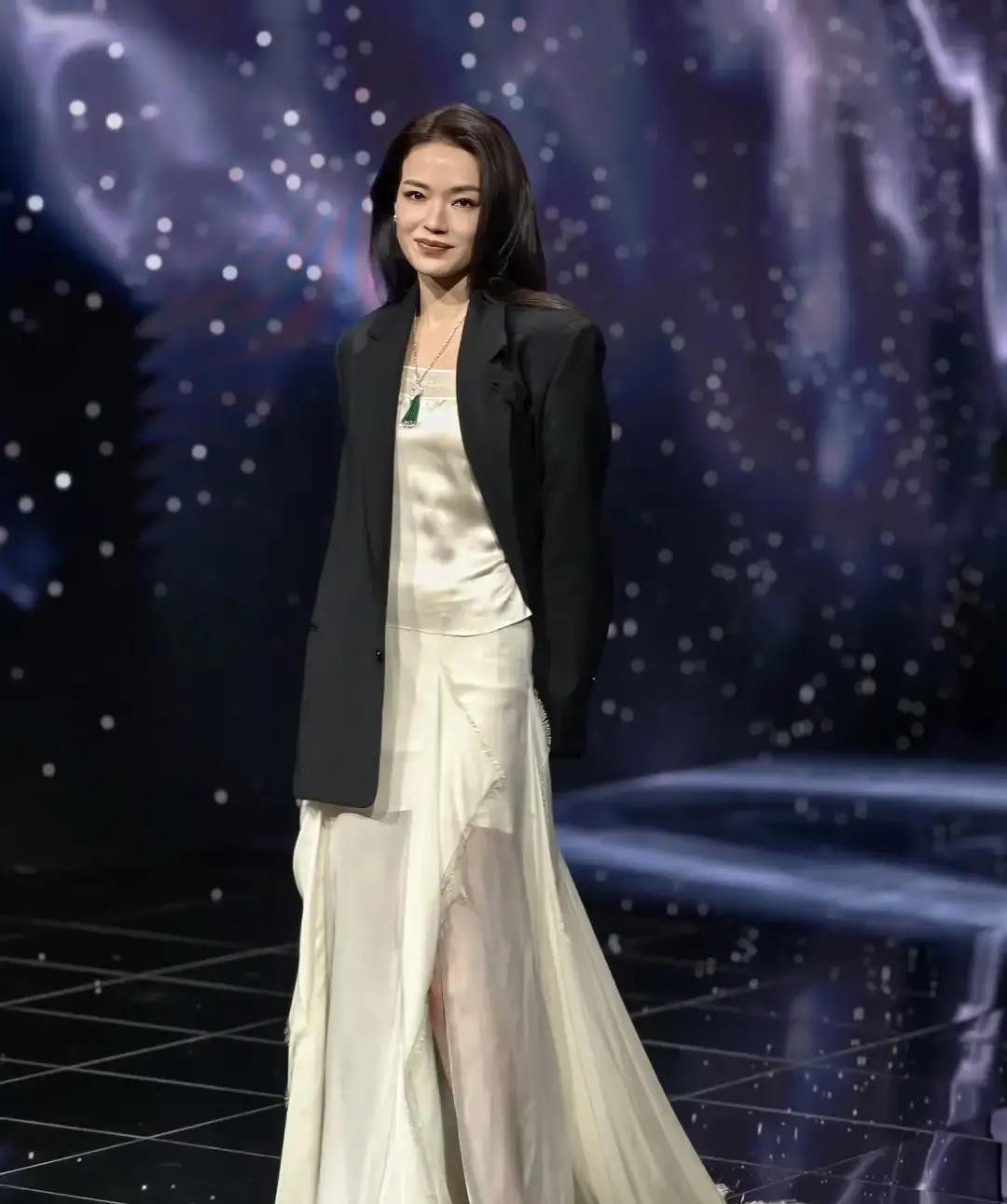舒淇昨晚在微博之夜红毯穿一身裸色雪纺长裙，外面套了件黑西装，头发随手挽个丸子，镜