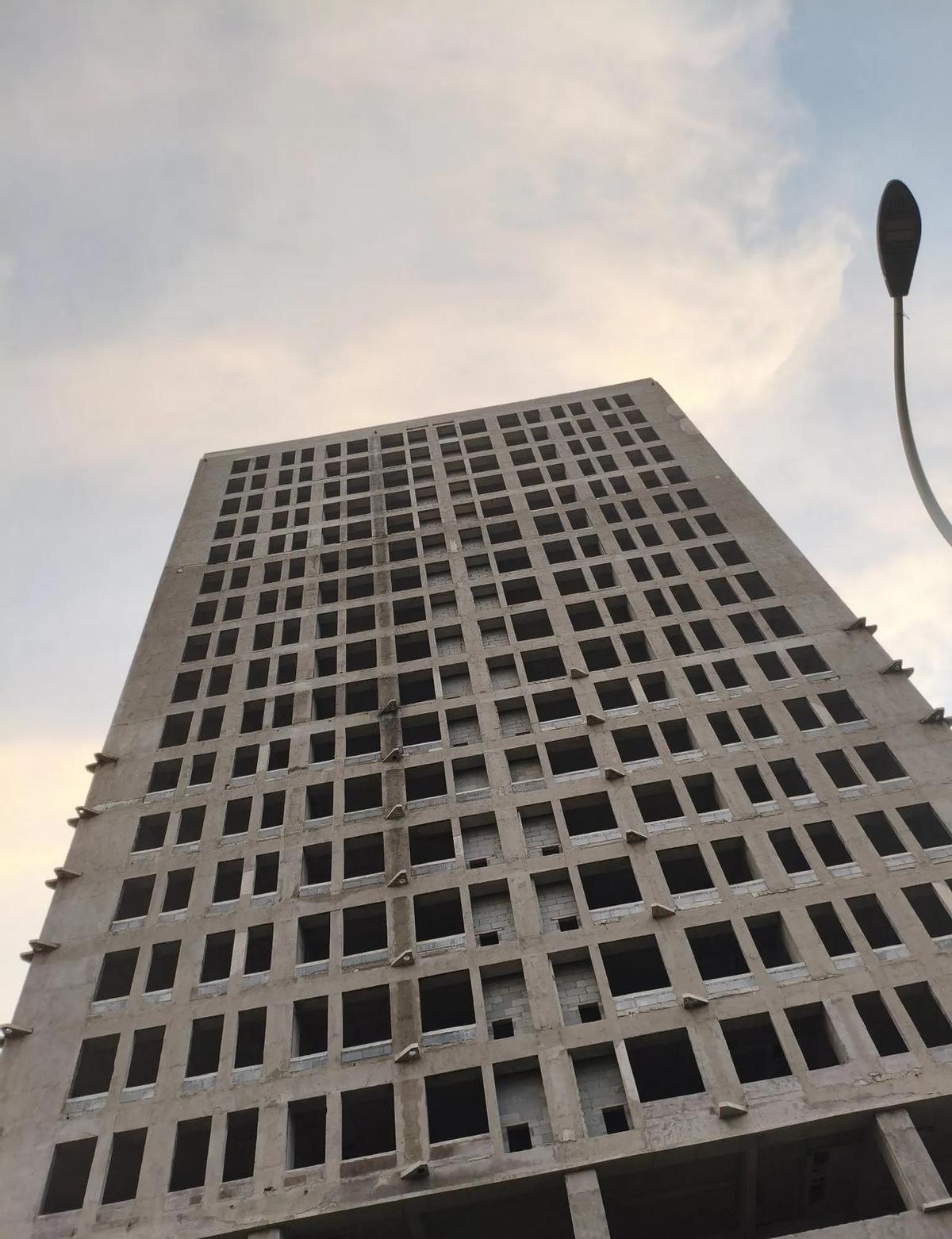 这栋楼，从2014年打完地基，就再没动过。
钢筋裸着，玻璃空着，墙皮没刮，电梯没