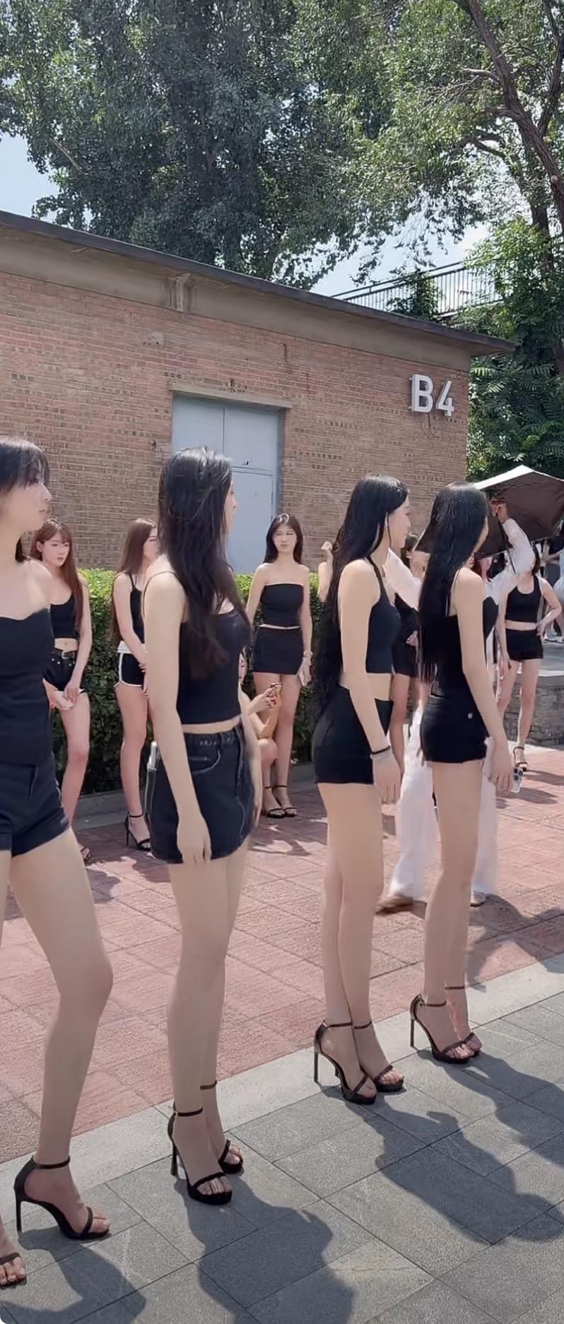 一群穿着黑色衣服的模特在户外排练。