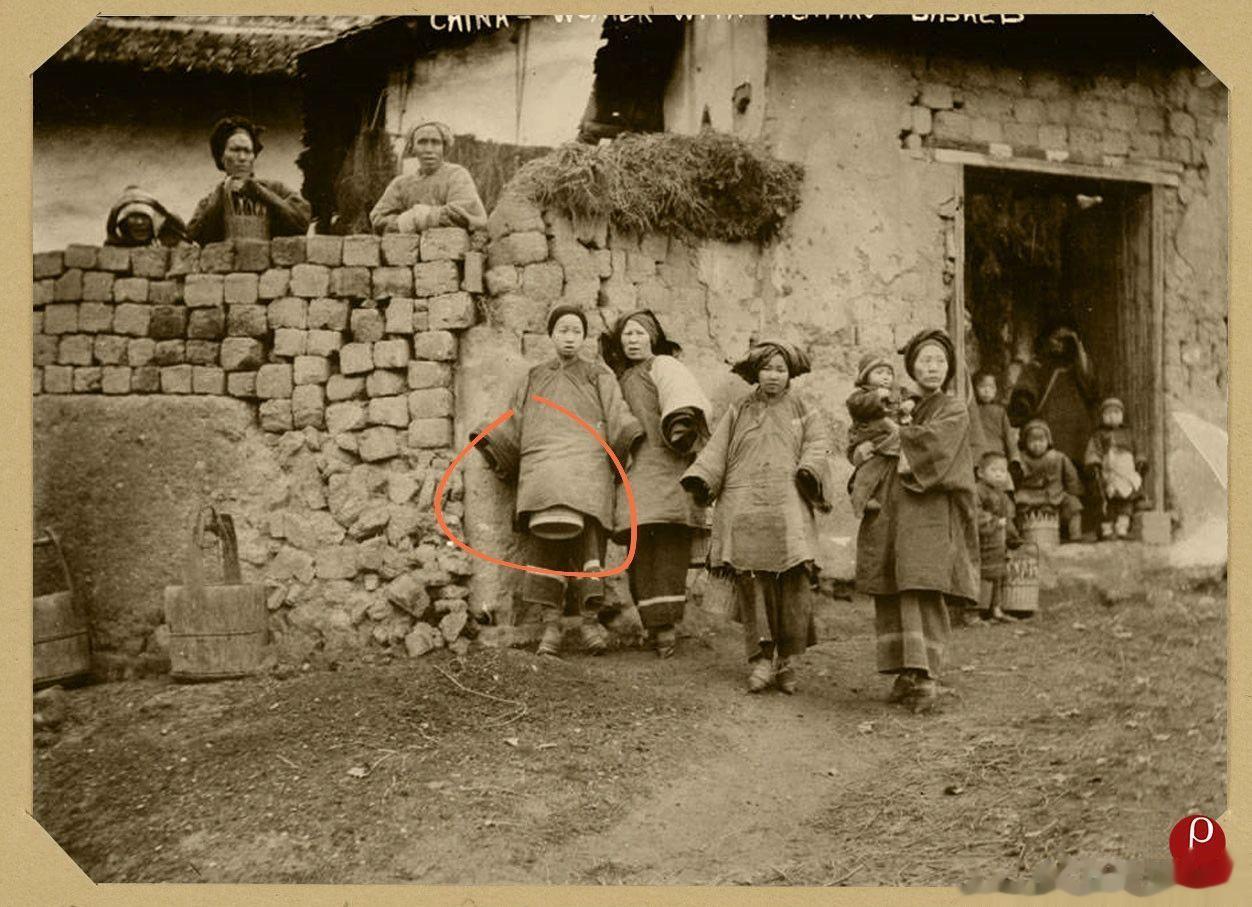 一个外国摄影师在农村拍摄乡村生活时，被围观的情景。这位小姐姐怀里居然揣着一个“桶