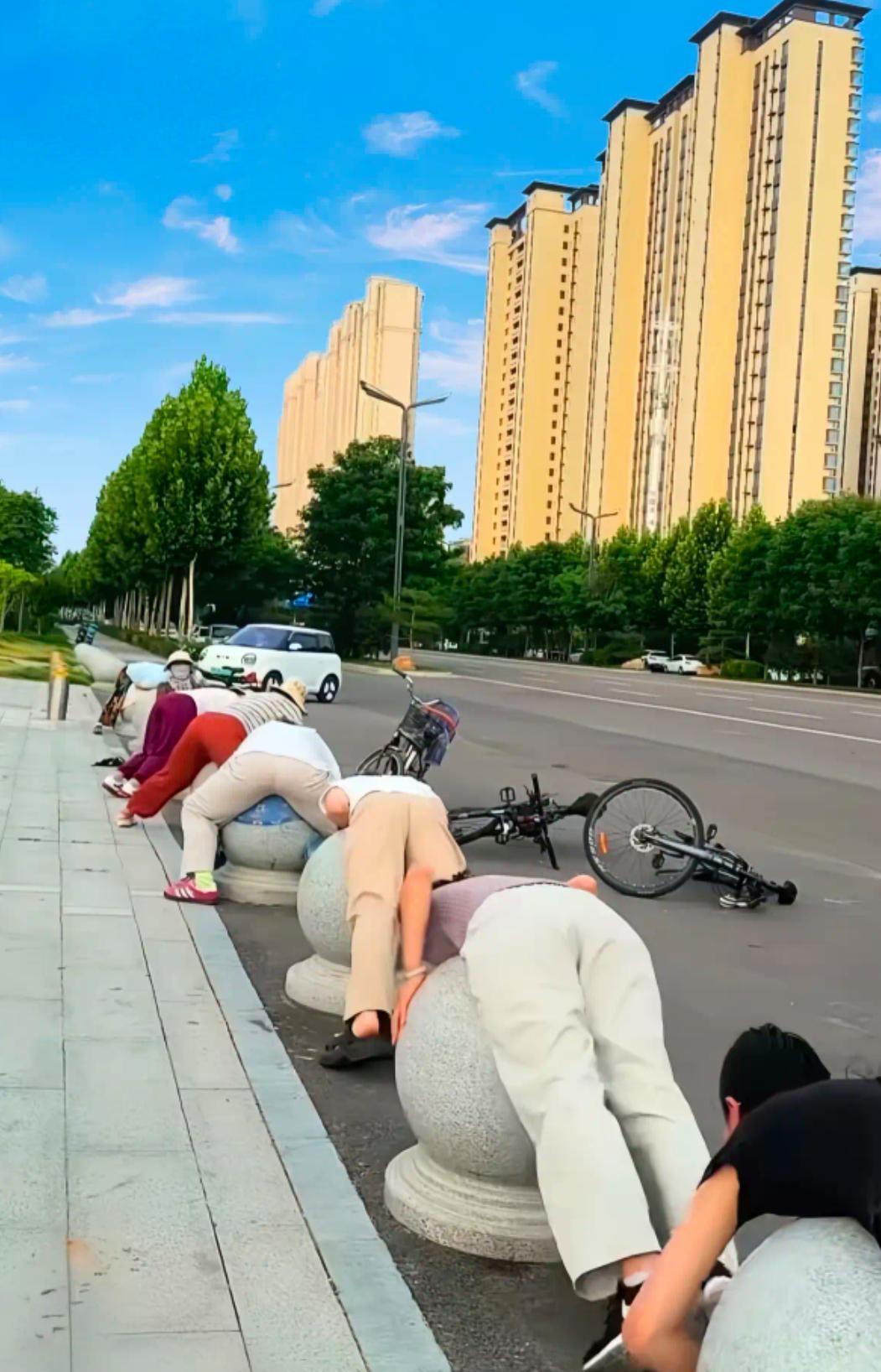 唉呀妈呀，这几个女人干啥呢

某地大马路上，见几个女人齐刷刷的全部趴在石墩上，把