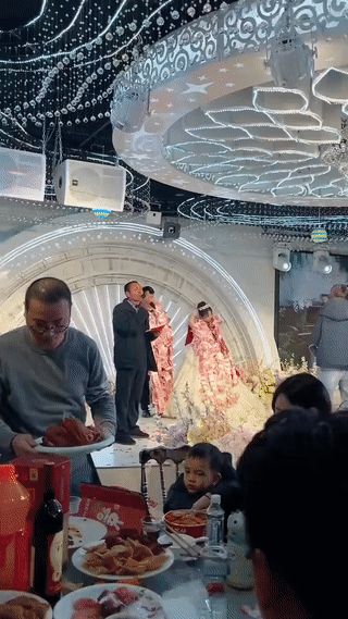 新郎新娘身上竟然都挂满了现金钞票？
他们这是在结婚呢？
还是在炫富啊？
看起来真