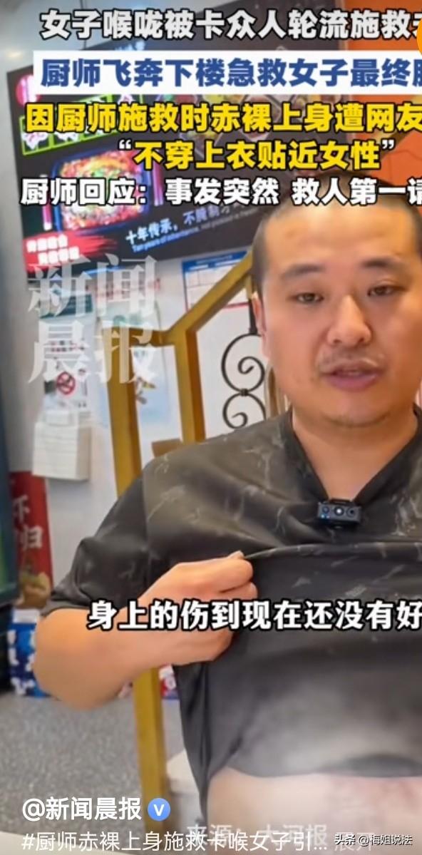 江苏苏州，烤鱼店内，一男厨师赤裸上身抱着一女子嗷嗷使劲，他们俩四周围满了人。原来