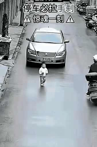 一辆轿车正往下溜，前面站着个小男孩！
​旁边有人想冲上去，脚一软摔了。千钧一发，