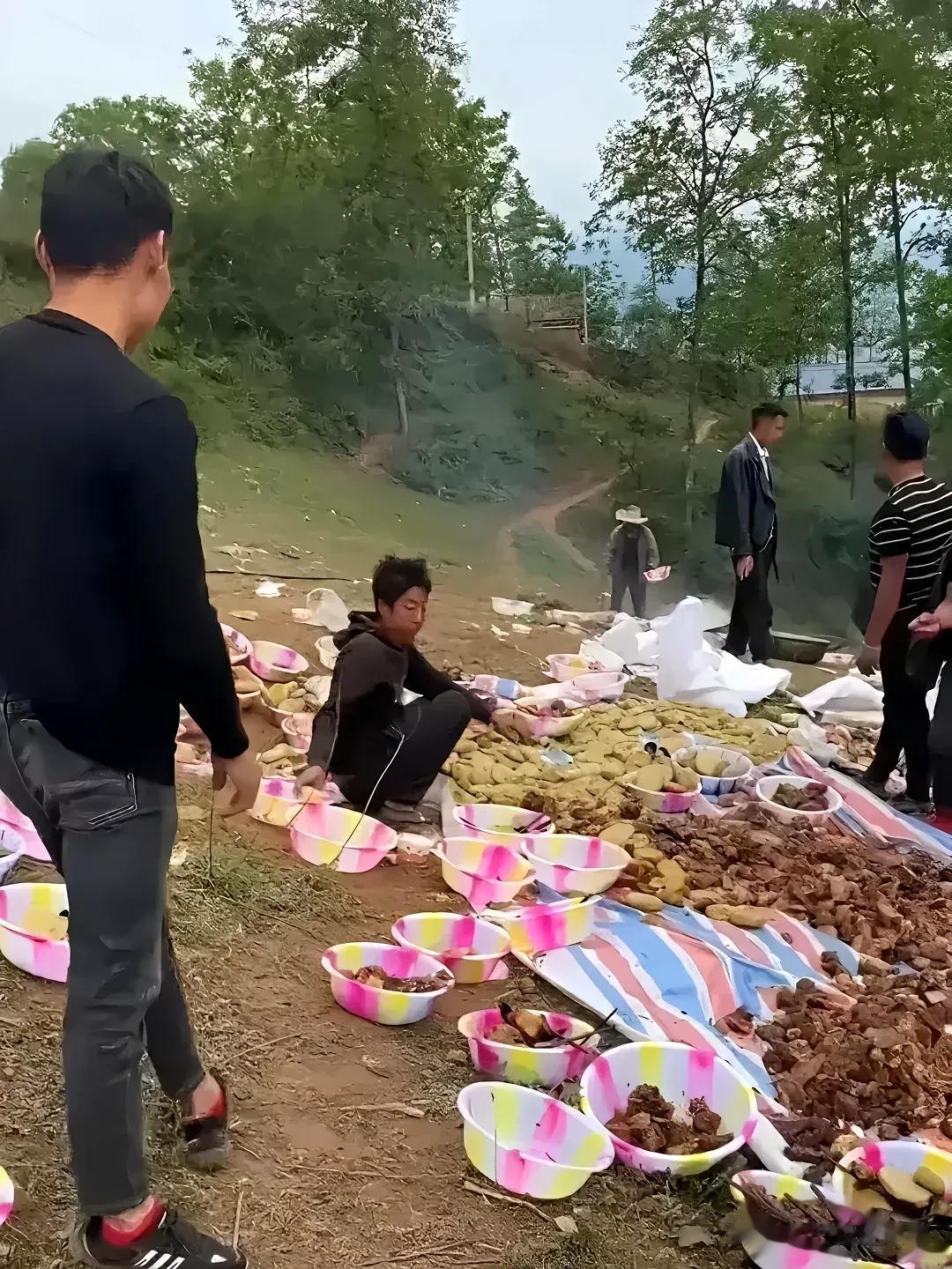篷布在地上徐徐铺开，几十平方米的面积，就是一个大餐桌，初步烹饪过的各类食物倾倒在