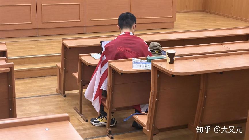 24岁，南京人，在莫斯科国立大学历史系课堂，身披旭日旗，课桌摆二战日军军帽。这个
