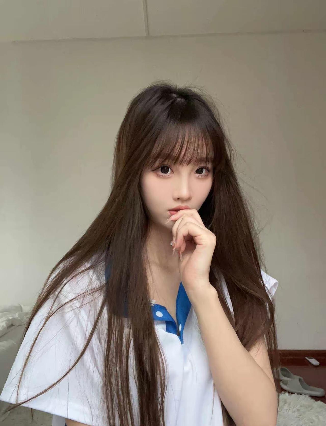 长发妹子，穿白衬衫，靠墙思考。