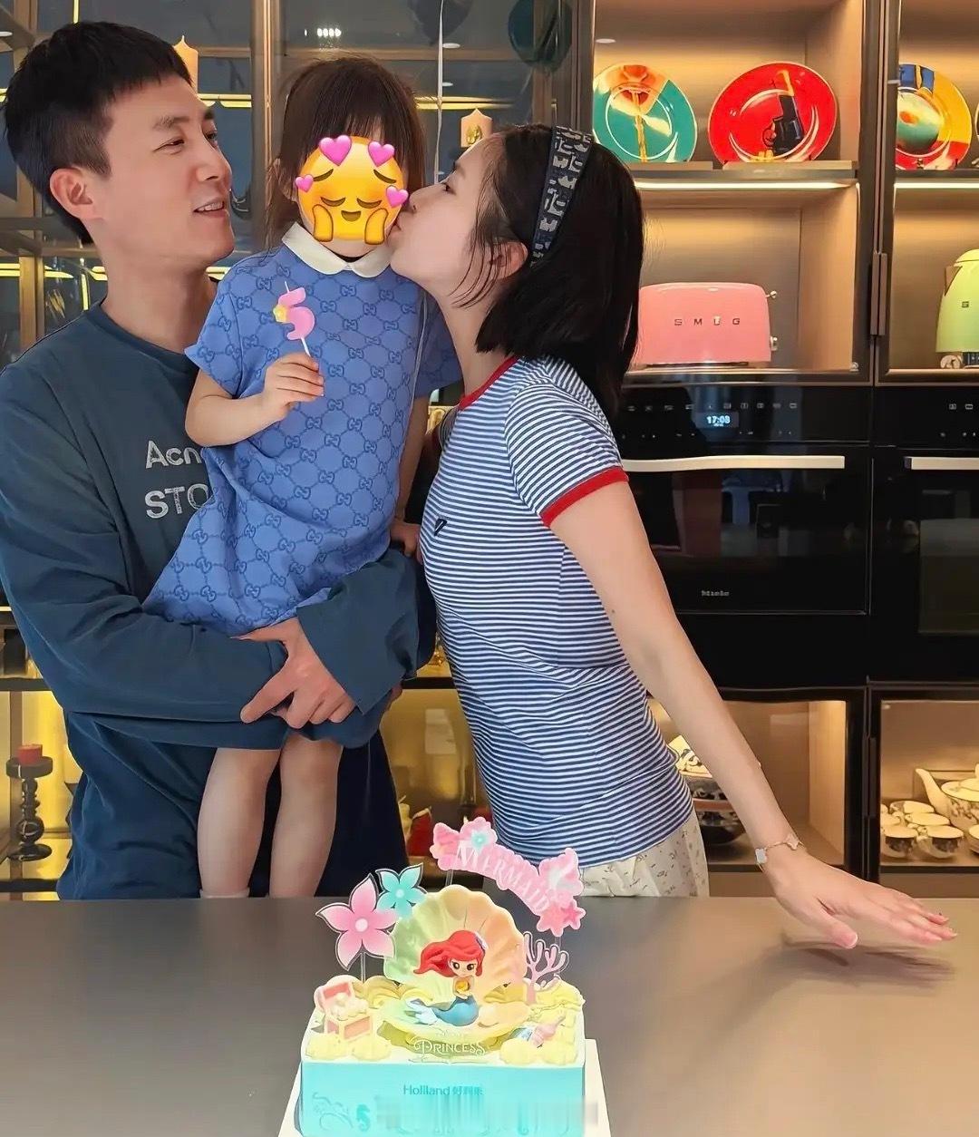 杜淳在家为女儿过生日，王灿晒三口之家合影，爸爸抱着女儿，妈妈亲吻孩子侧脸，温馨又