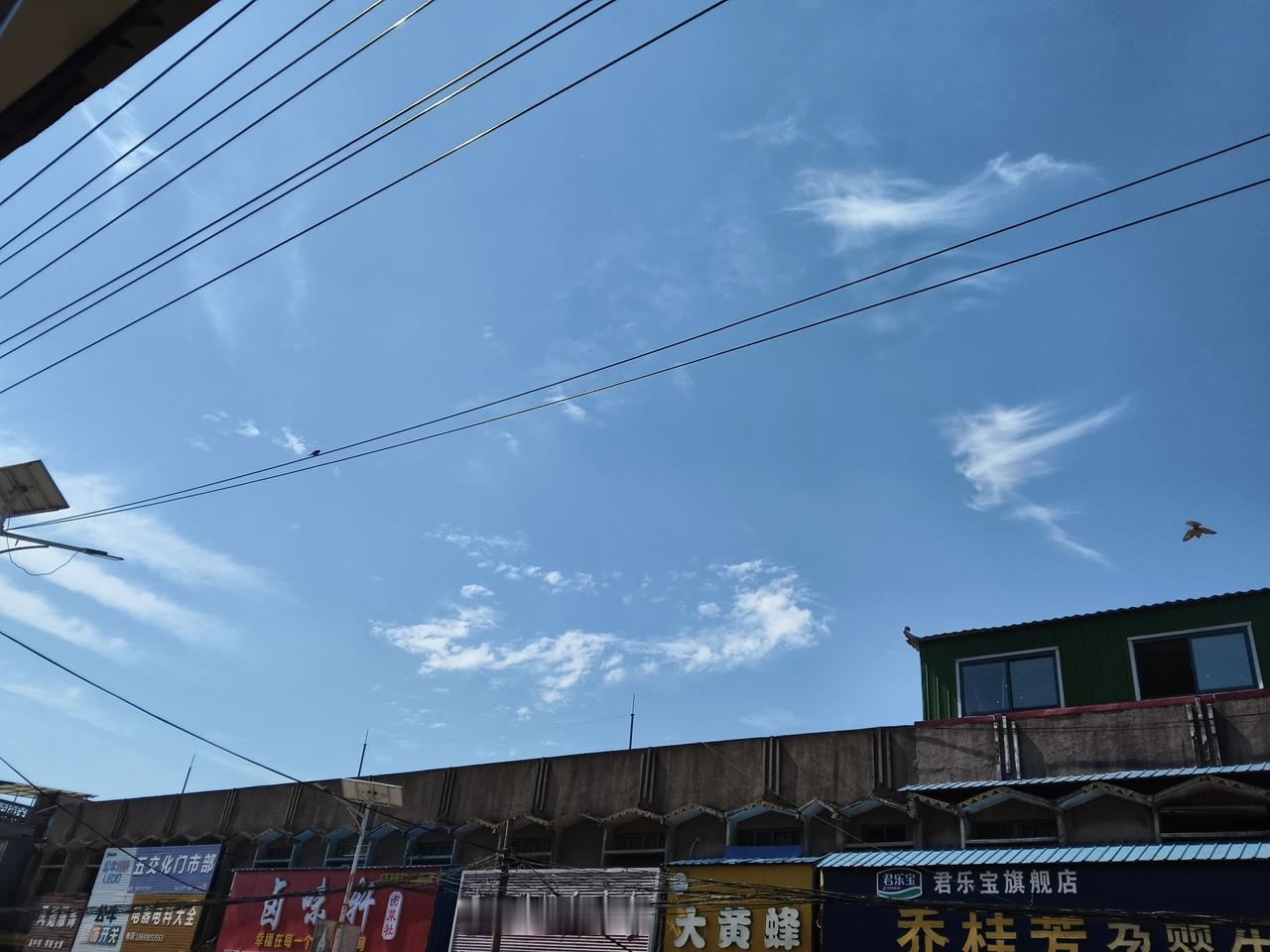 万里长空碧澄如洗，几絮白云是擦拭的手帕。